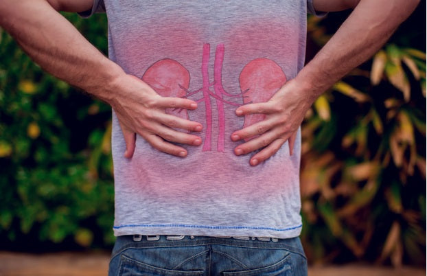 People, health care and medicine concept - unhappy man suffering from pain in back or kidneys sitting on bench on street. Source: DepositPhotos